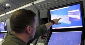 US soldier pointing at monitor view of island
