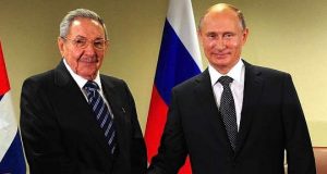 Raul Castro and Vladimir Putin shake hands