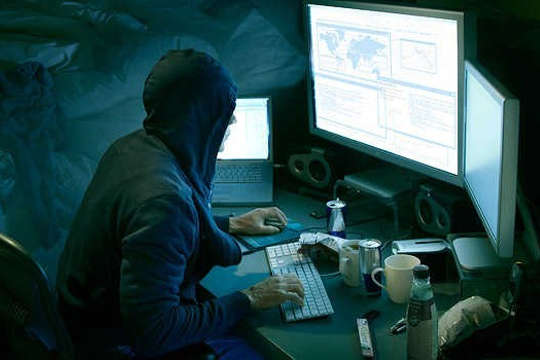 Hooded haker in front of computer